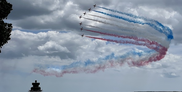The Red Arrows in the sky with coloured smoke behind