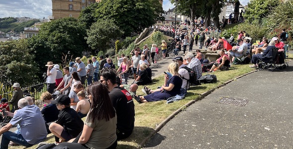 People sitting on a grassy embankment
