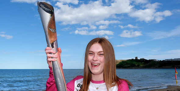 A young woman holding the Queen's Baton